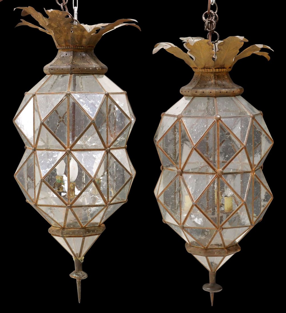 (2) LARGE IRON & GLASS FOLIATE OCTAGONAL 3-LIGHT LANTERNS, MEXICO: (pair) Large patinated iron and glass three-light hanging lanterns, Mexico, each having flared foliate ceiling mount, above waisted octagonal frame, terminating on pointed drop finial, hinged access d