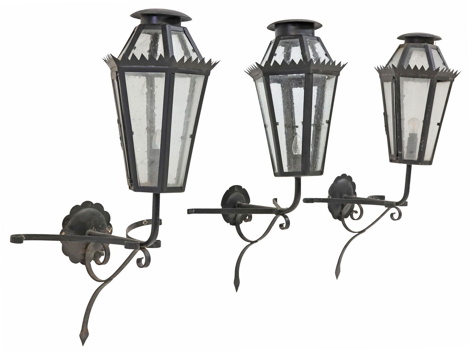 (3) PAINTED IRON & GLASS 1-LIGHT WALL BRACKET LANTERNS, MEXICO: (lot of 3) Black-painted iron and glass one-light wall-mounted lanterns, Mexico, each with a tapered hexagonal form, enclosing single light, issuing from scrolled wall bracket, hinged access panel at