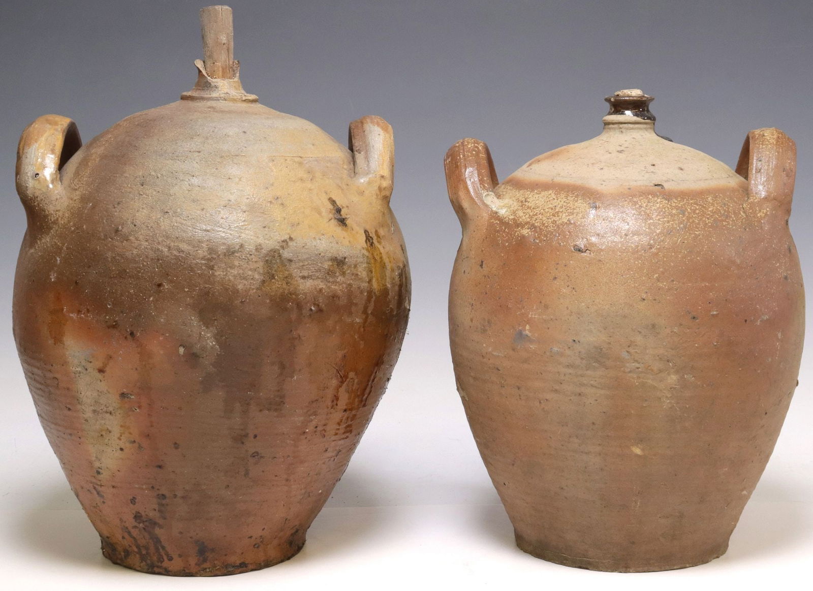 (2) FRENCH PROVINCIAL STONEWARE OIL JUGS: (lot of 2) French Provincial stoneware oil jugs, each with dual side handles over tapered body, largest: approx 17"h, 11"w, 11"d, 27.5lbs total