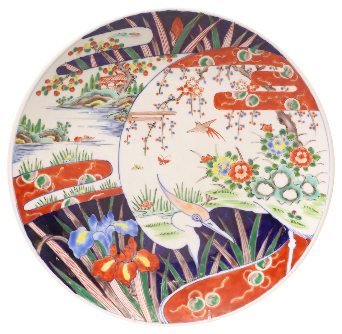 JAPANESE ARITA STYLE IMARI PALETTE PORCELAIN CHARGER: Japanese Arita style Imari porcelain charger, depicting a crane among blossoming trees, with architectural pagodas and foliate motifs, four-character mark underfoot, approx 15.75"diam, 4.25lbs