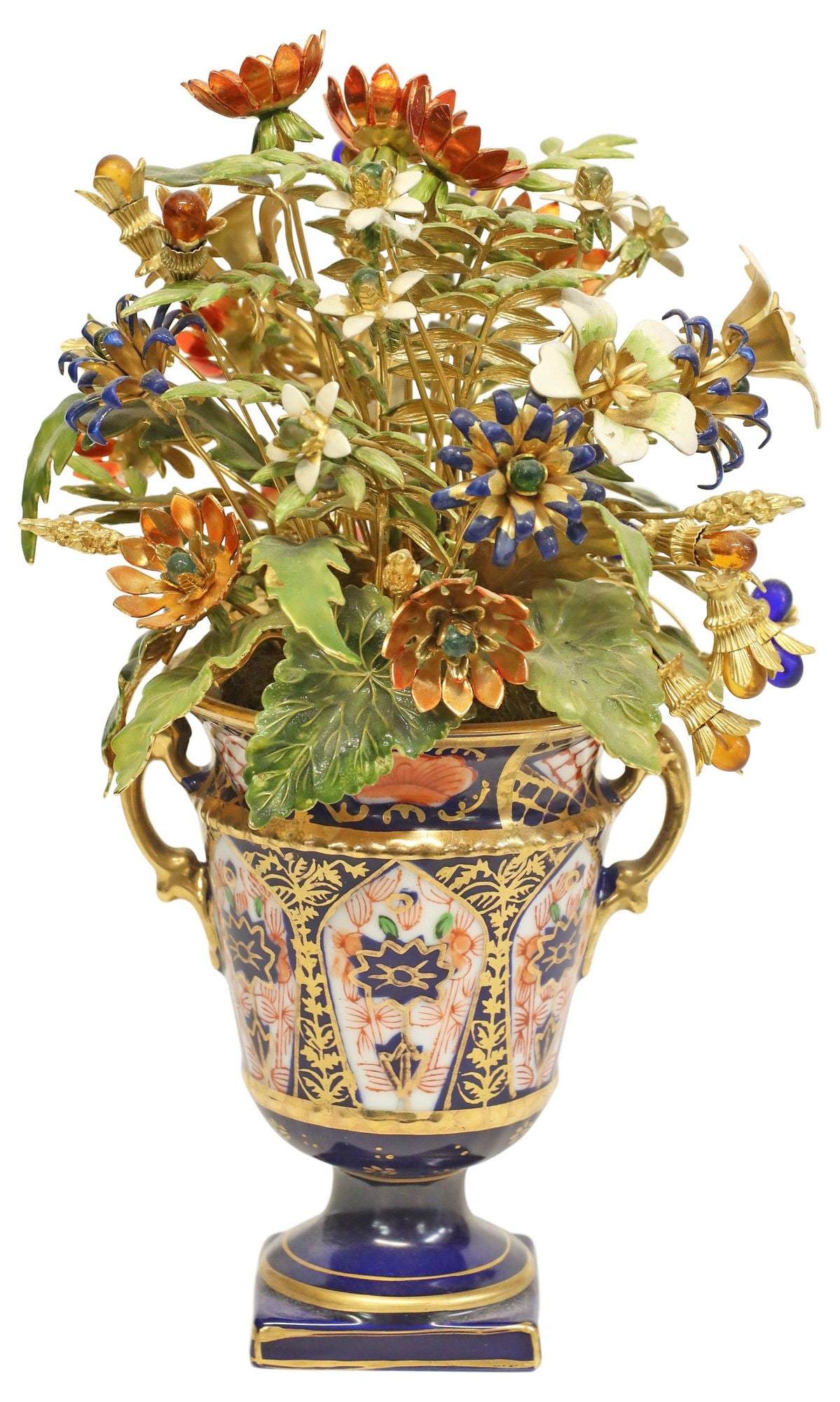 MINIATURE ENAMEL FLOWER ARRANGEMENT IN ROYAL CROWN DERBY IMARI URN: Miniature flower arrangement, having gilt metal branches with hand-painted enamels, in an English bone china Imari palette vase, attributed to Royal Crown Derby, with parcel-gilt trim on cobalt ground