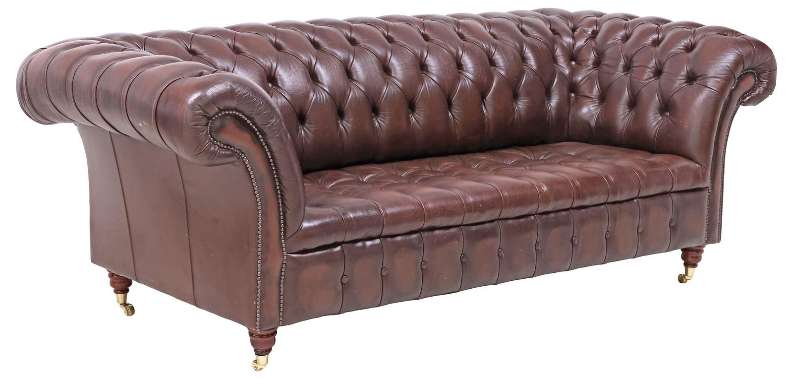 ENGLISH BROWN BUTTONED-LEATHER CHESTERFIELD SOFA: English Chesterfield three-seat sofa, late 20th c., covered overall in brown leather, with button-tufted back, seat, and out-turned arms, on turned legs with brass casters, approx 32.25"h, 85&quo