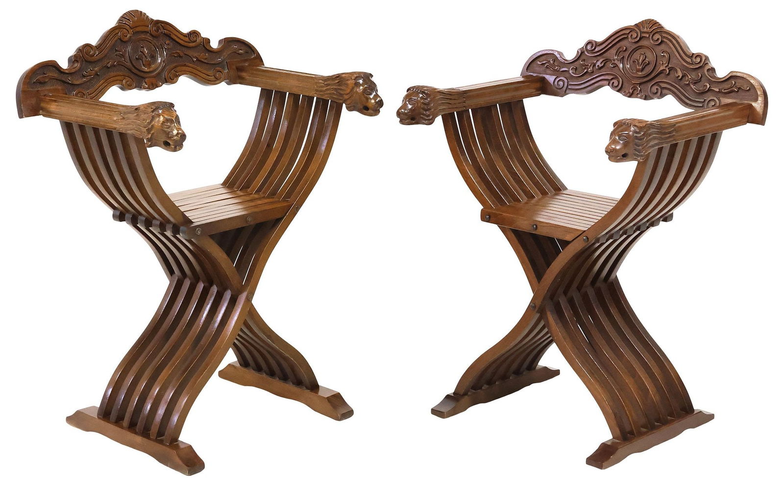 (2) ITALIAN RENAISSANCE REVIVAL WALNUT SAVONAROLA CURULE CHAIRS: (pair) Italian Renaissance Revival carved walnut Savonarola chairs, early 20th c., having fanned scrolling crest, over folding slatted frame, lion bust hand holds, rising on curule base, ending on bri