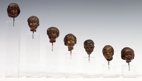 (7) GLENNA GOODACRE (1939-2020) SMALL BRONZE CHILDREN MASKS ON ACRYLIC STANDS
