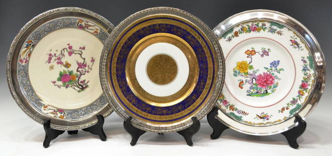 (3) FINE STERLING MOUNTED PORCELAIN CABINET PLATES: (lot of 3) Collection of porcelain chargers, each mounted with sterling silver rim, comprising:(1) Lenox 'Ming-Birds' plate, central well decorated with cherry blossom and butterflies on a cream