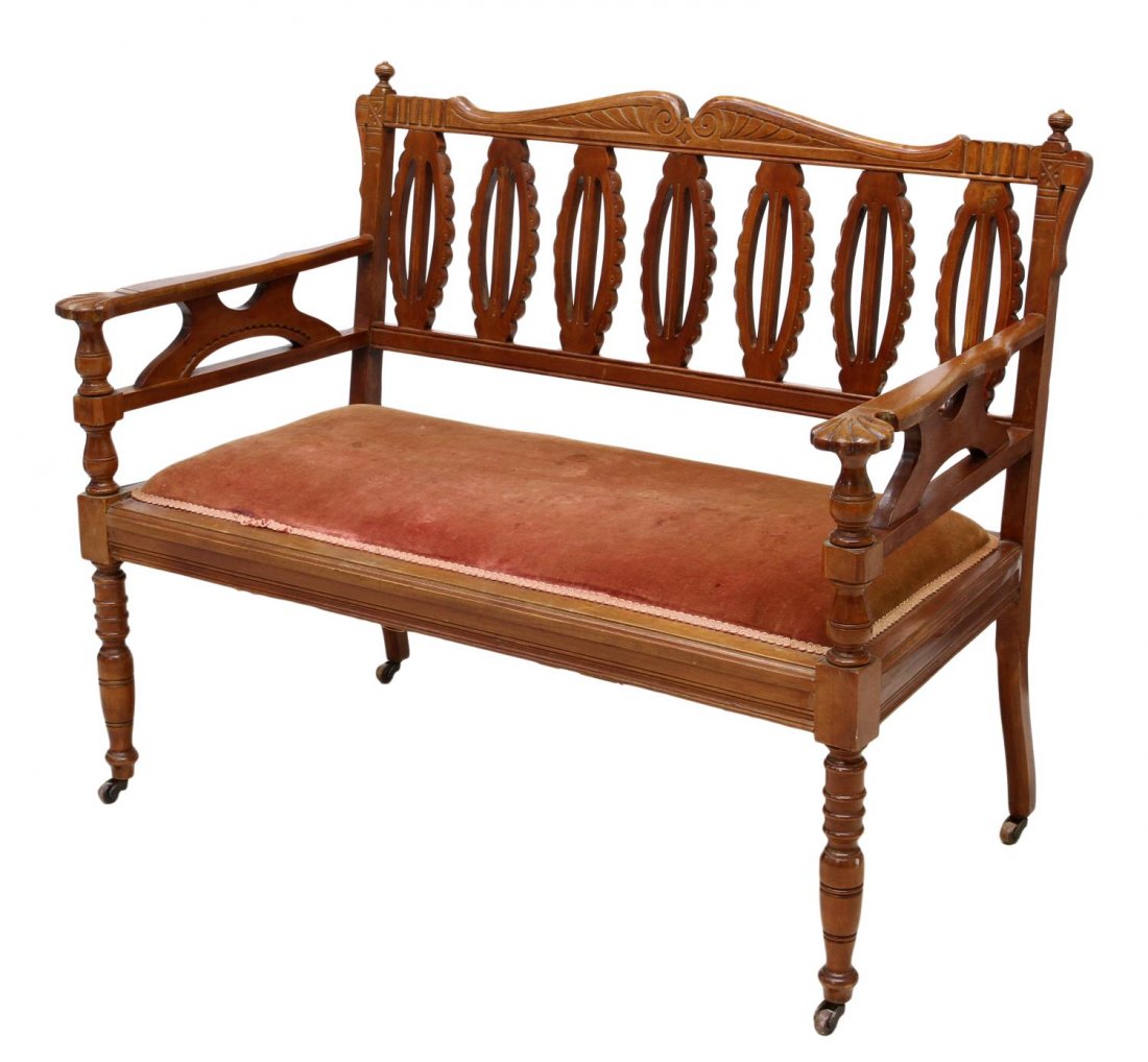 ANTIQUE CARVED TEAKWOOD SETTEE: Teakwood settee, 20th c., a split pediment crest rail over pierced oval back supports, the arms terminating in foliate form, later stained fabric at the padded seat, rising on turned front legs with c