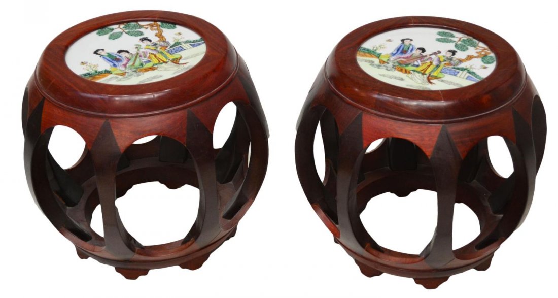 (PAIR) CHINESE HARDWOOD & PORCELAIN BARREL STOOLS: (pair) Chinese hardwood barrel stools, hand painted porcelain seats, showing a figural garden scene of beauties playing music, rising on on eight bow form braces, terminating in short bracket feet, 13