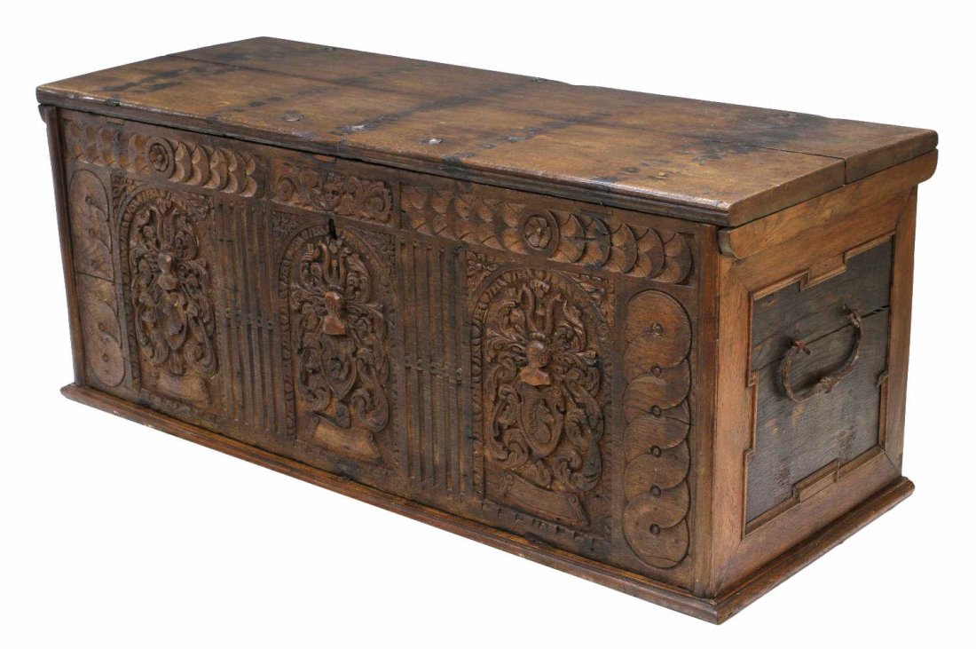 CONTINENTAL RELIEF CARVED 18TH C. TRUNK: Continental oak trunk, 18th c., the front with profuse relief foliate carving at three panels each with carved knight heads over a eagle head, flower and horse head, the top with large hand forged str