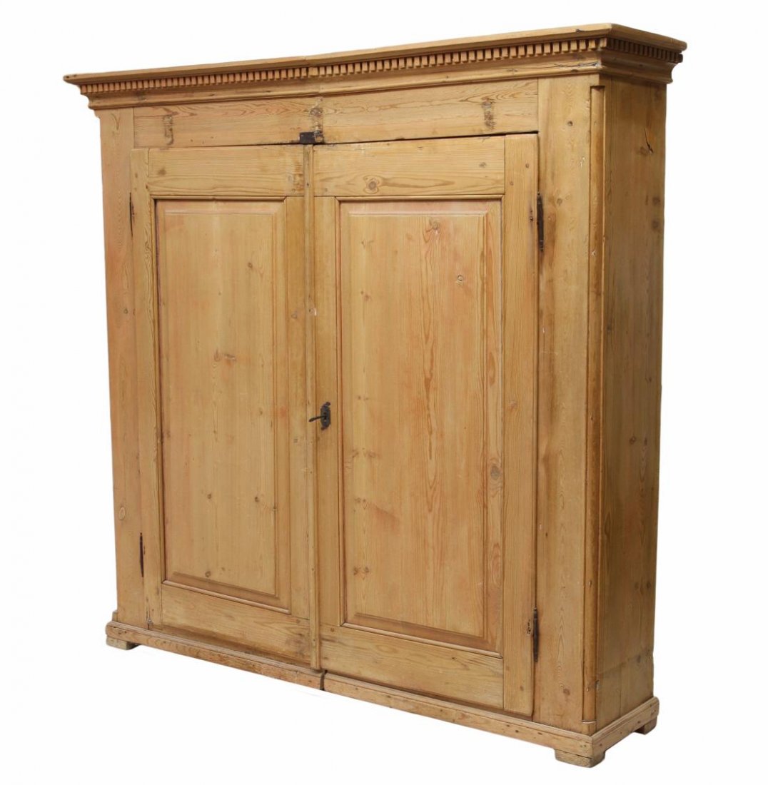 ANTIQUE PINE TWO DOOR CUPBOARD: Pine double door cupboard joined at center, a stepped cornice over dentil molding, two doors opening to interior shelves, plinth base raised on short block feet, later additions to interior, slight po
