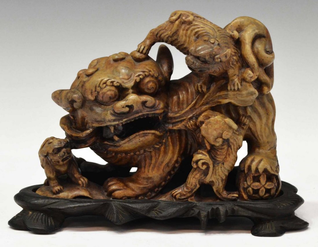 CHINESE CARVED SOAPSTONE MOTHER FOO DOG & PUPS: Chinese carved soapstone figural group, a mother foo lion with three foo lion cubs, loose ball in mouth, rising on a fitted carved wood stand, overall: 5"h, 6.75"w, 3.25"d, 2.25lbs Start Price: $80.00