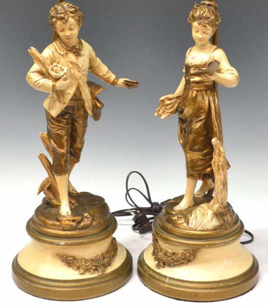 AFTER E. BRUCHON PARCEL GILT FIGURAL TABLE LAMPS: (pair) Parcel gilt patinated metal figural table lamps, after Emile Bruchon (French, 1806-1895), a young boy and girl, each with book and wheat standing on a naturalistic ground, circular base with ap