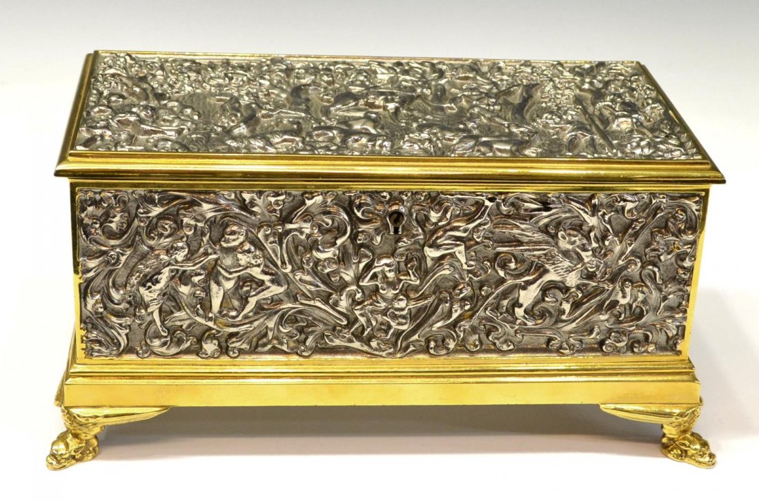 GERMAN SILVER & GILT RELIEF FIGURAL JEWELRY CASKET: German silver metal jewelry casket thoroughly cast with figures and dense foliates in relief, each panel enclosed by gilt metal trim, raised on four figural feet, makers mark, Made in Germany on base,