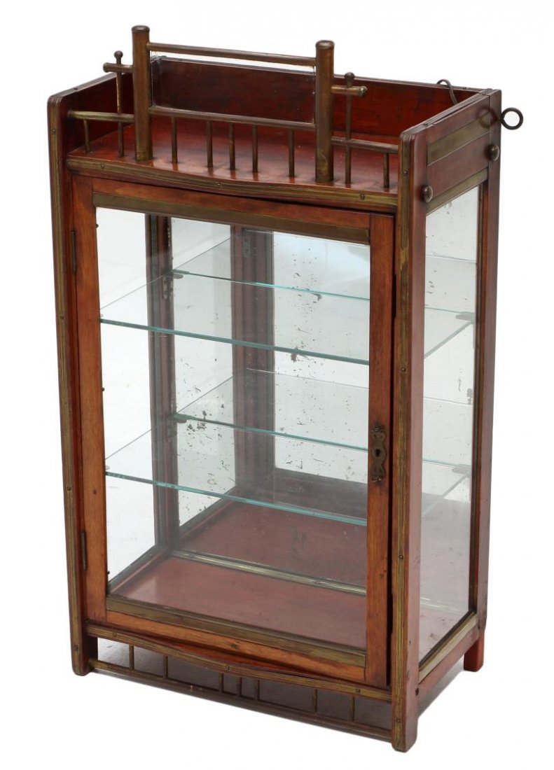 HANGING WALL DISPLAY CABINET: Mahogany finish hanging lighted wall display cabinet, early 20th c., a brass and glass crest over a single glass faced door opening to mirrored interior with glass shelves, wood and metal base, silver