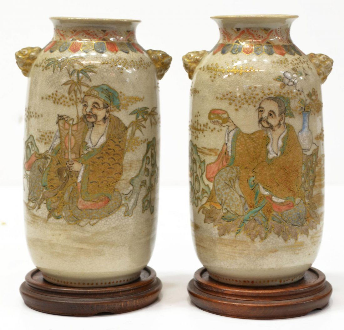 (PAIR) JAPANESE SATSUMA-STYLE EARTHENWARE VASES: (pair) Japanese Satsuma-style earthenware vases, early 20th c., each with a polychrome garden scene with a Chinese sage, gilt moriage accents, flanked by gilt lion mask handles, with wooden stands, ov