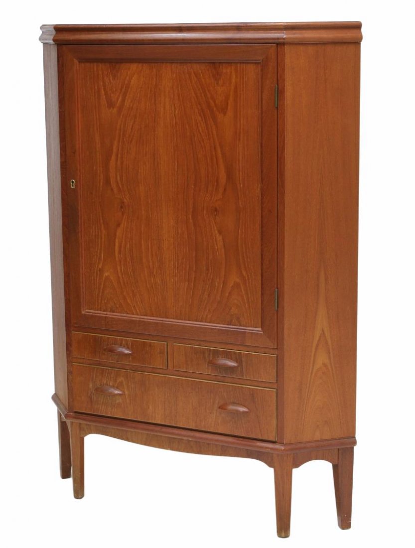 DANISH MID-CENTURY MODERN CORNER CABINET: Danish mid-century modern teakwood corner cabinet, a single door opening to the birch lined interior, two short exterior drawers over one long drawer, rising on tapered legs, 51.5"h, 37"w, 24.25"d Sta