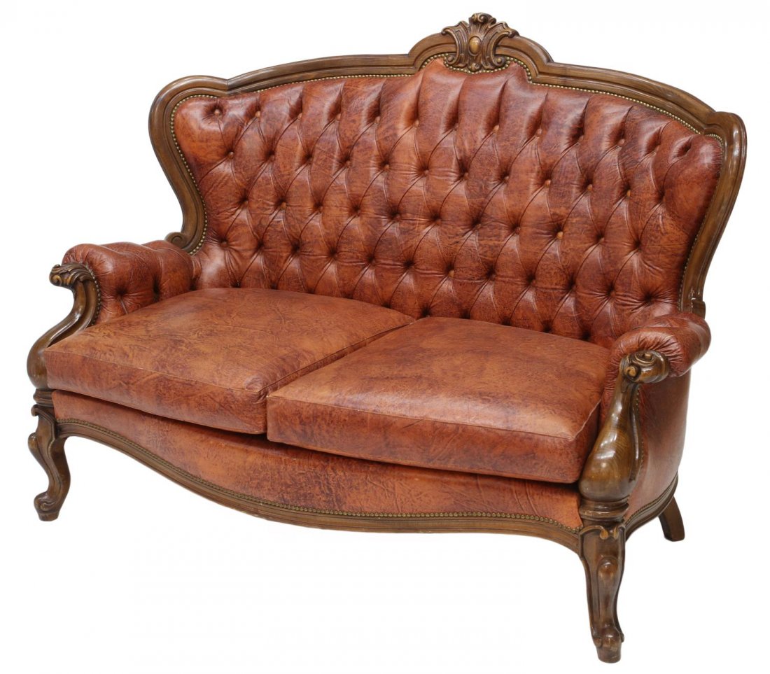 ITALIAN LOUIS XV STYLE BUTTONED LEATHER SOFA: Italian Louis XV style sofa, 20th c., having a stylized crest on the shaped back rail over buttoned leather upholstery, padded arms with foliate carved hand holds, two cushions, rising on scrolled foo