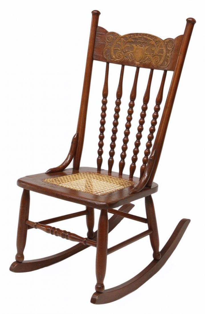 PRESS BACK SEWING ROCKING CHAIR: Press back sewing rocker with turned vertical spindles, cane seat, turned legs set on rockers, 35"h, 16"w, 25"d Start Price: $40.00