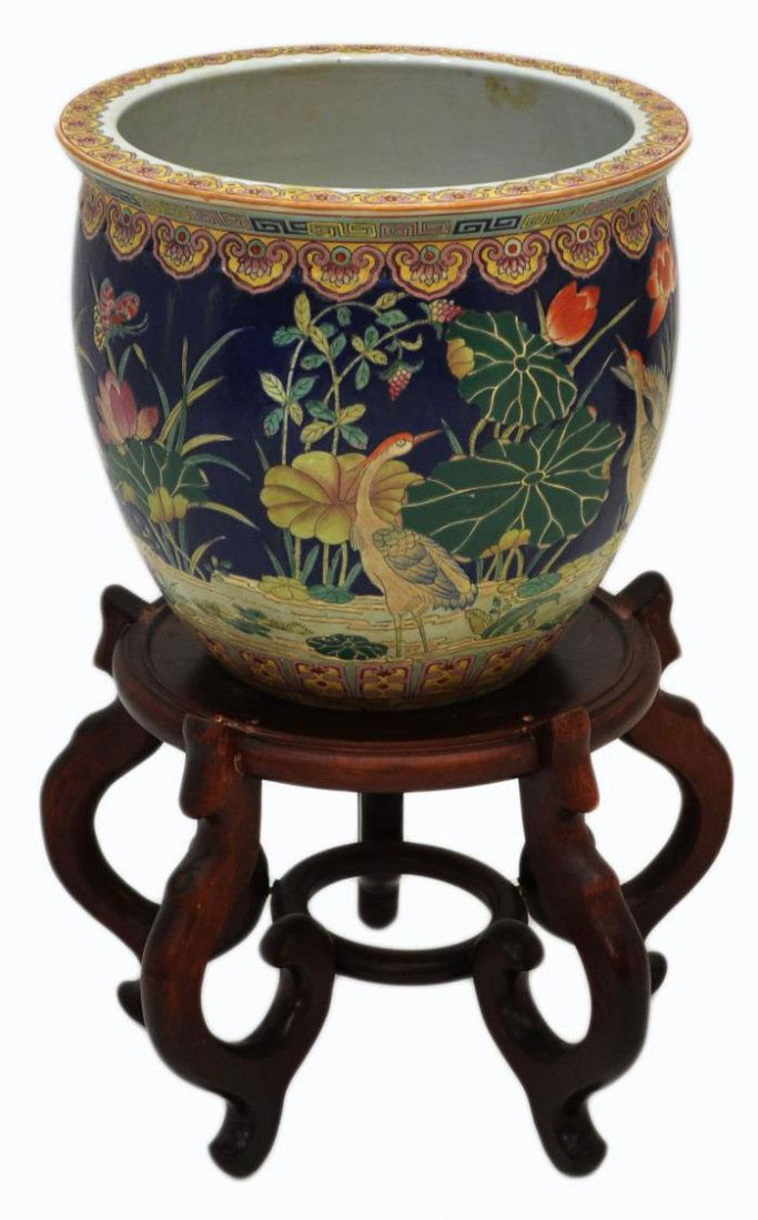 LARGE ASIAN ENAMELED PORCELAIN FISH BOWL ON STAND: Large Asian porcelain planter, ruyi-head and key patterned trim, the exterior showing a pond scene with heron, lily pads, foliates and butterflies, the interior having vibrant Koi fish, characters und
