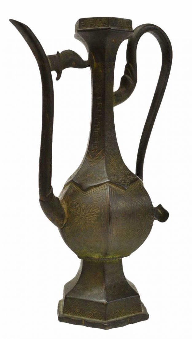 TALL ANTIQUE BRONZE EWER: Antique Bronze pitcher with curved handle and long spout, lacking figural lid, 9.25”h, 2.5lbs Start Price: $50.00