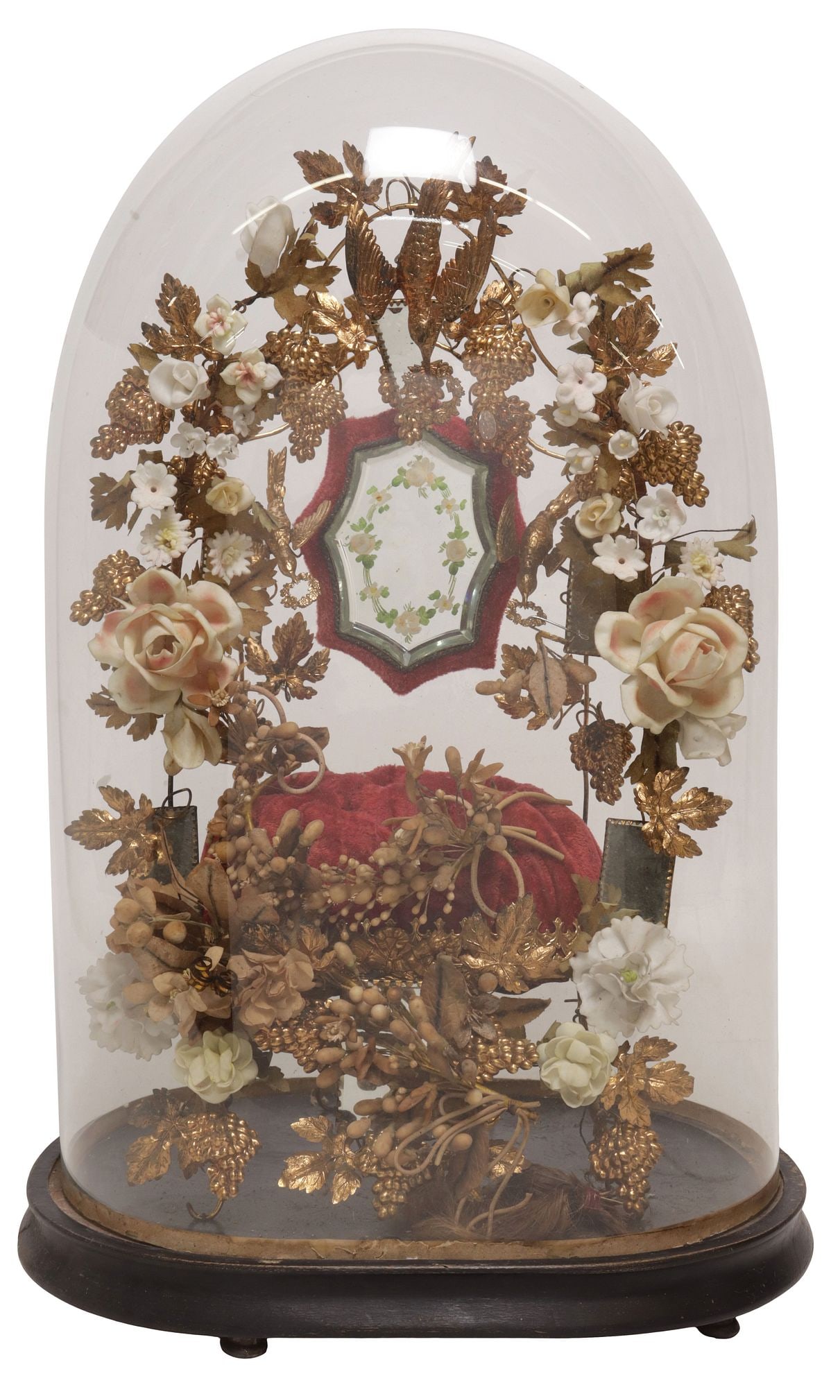 FRENCH GLOBE DE MARIEE / BRIDE'S GLOBE IN CLOCHE: French globe de mariee/ bride's globe, late 19th c., glass cloche/ dome on ebonized base, enclosing gilt metal frame, with faux floral and foliates, central geometric mirror, on a red fabric cushion,