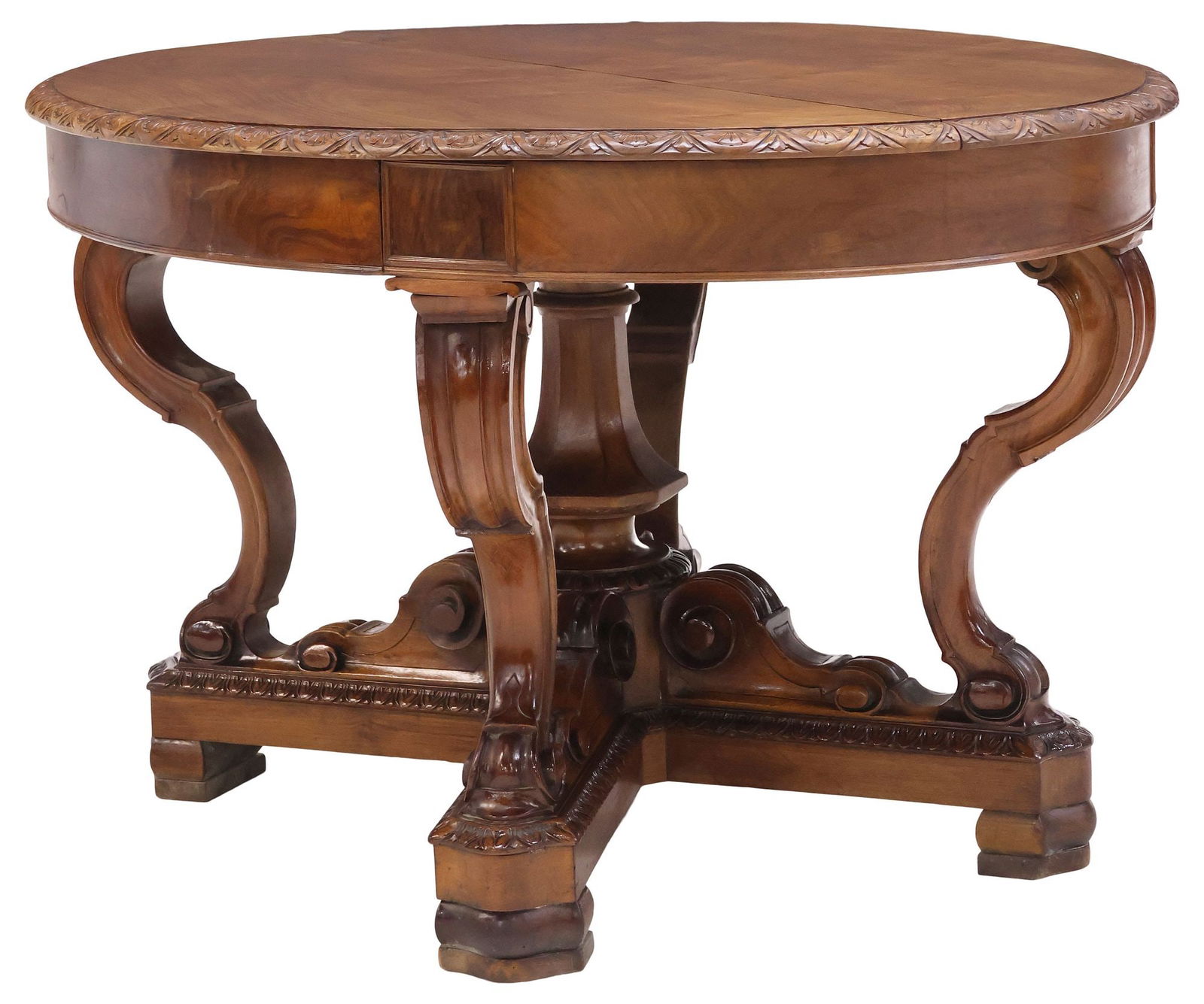 ITALIAN CARVED WALNUT EXTENSION DINING TABLE: Italian carved walnut extension dining table, 19th c., having oval top with molded floral lunette trim, rising on central faceted octagonal standard, and scrolled supports, ending on quadripartite bas