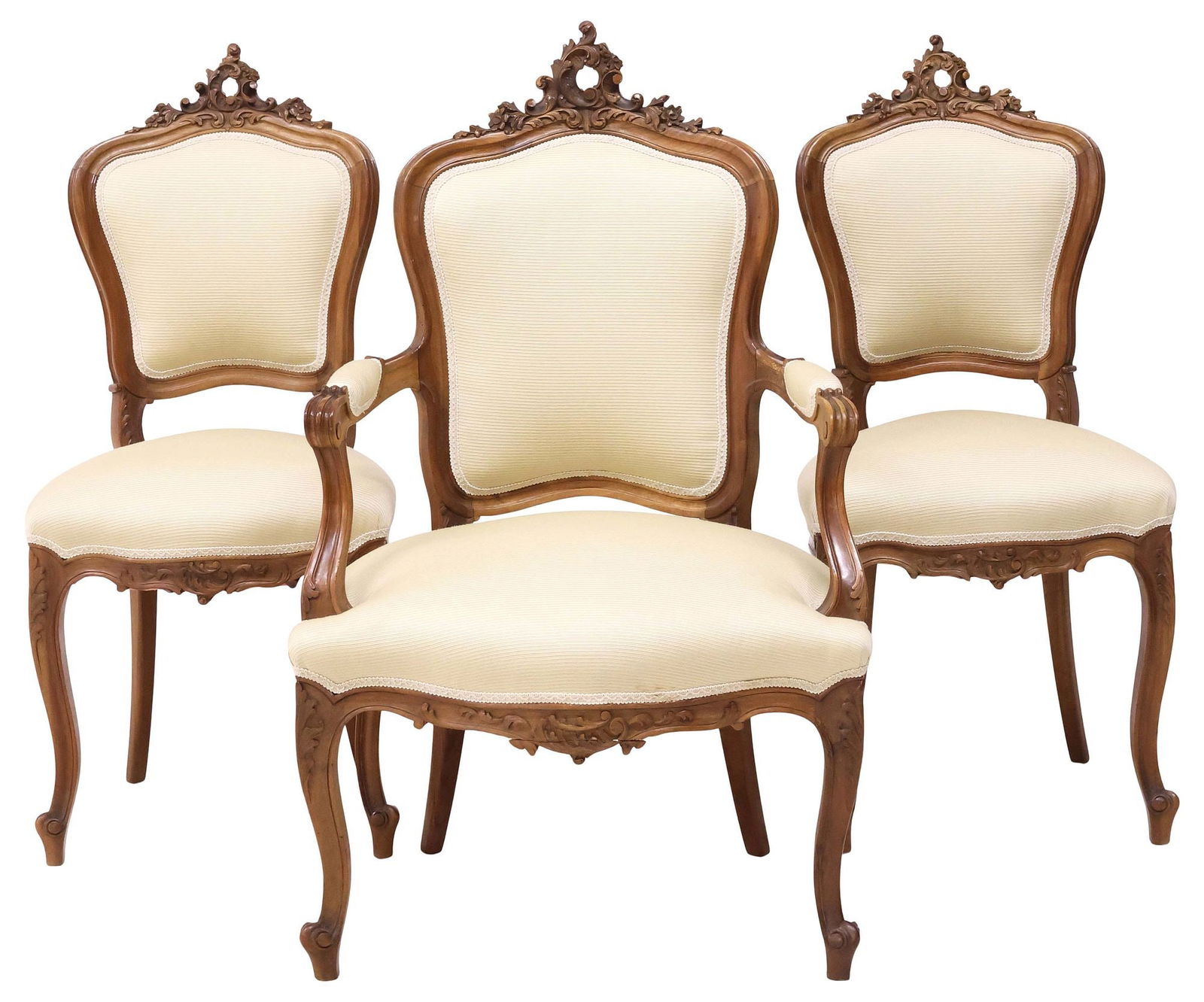 (3) ITALIAN LOUIS XV STYLE CARVED WALNUT ARM & SIDE CHAIRS: (lot of 3) Italian Louis XV style walnut side chairs, early 20th c., having finely carved rocaille crest, padded back and seat in a ribbed cream fabric upholstery, rising on frontal cabriole legs head
