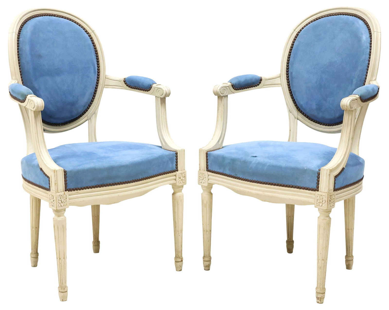 (2) FRENCH LOUIS XVI STYLE UPHOLSTERED ARMCHAIRS / FAUTEUILS: (pair) French Louis XVI style fauteuils/ armchairs, early 20th c., each in a white-painted finish, having padded oval back, seat, and arms in a blue fabric upholstery, with nailhead trim, rising on ta