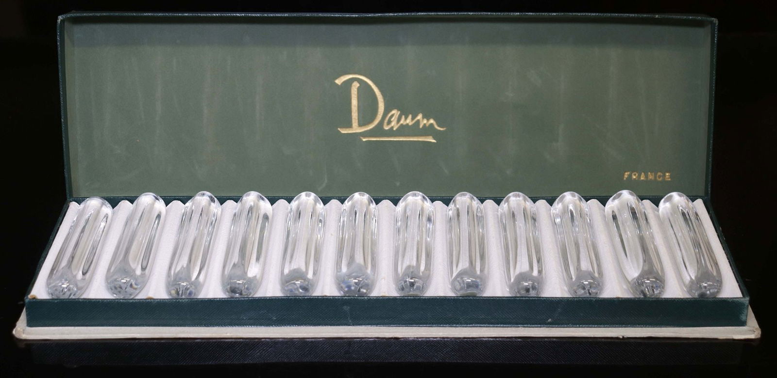 (12) FRENCH DAUM COLORLESS CRYSTAL KNIFE RESTS IN BOX: (lot of 12) French colorless crystal knife rests, Daum, 20th c., each of elongated form with dimpled sides, engraved maker's mark Daum France, housed in a branded box, knife rest: approx 3.75"l, box: