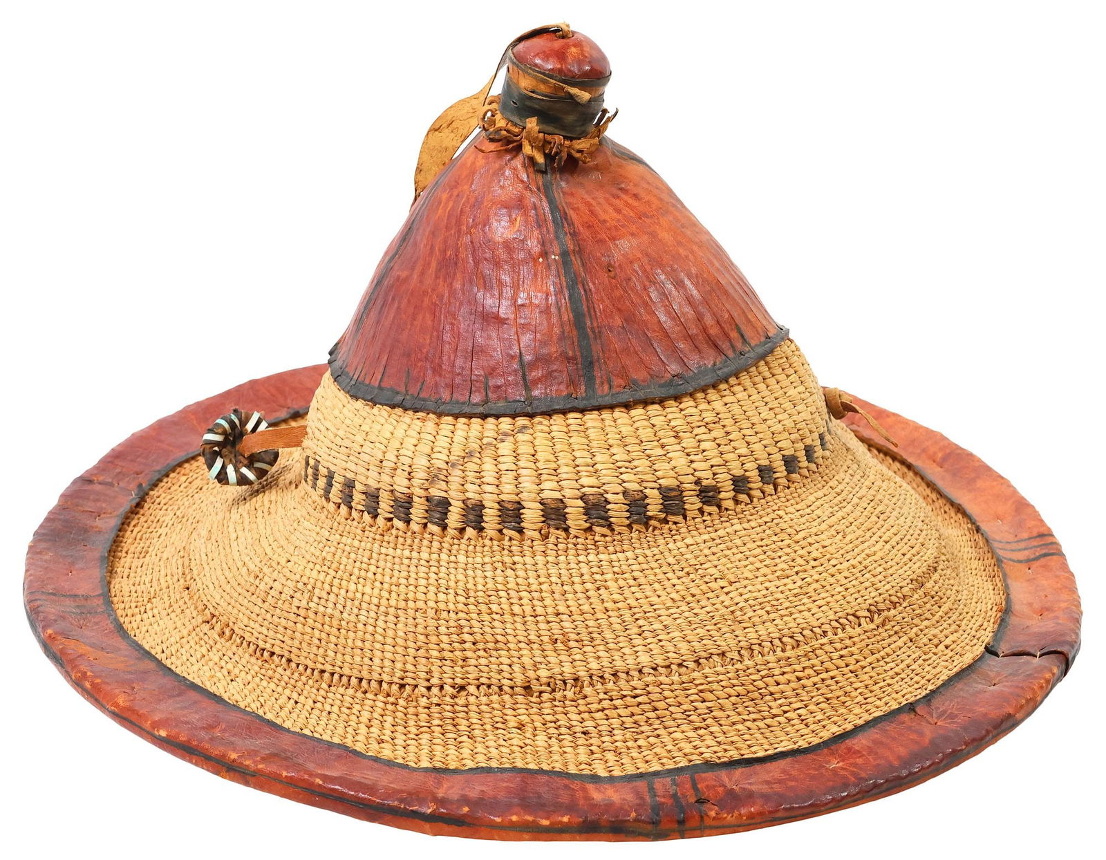 WEST AFRICAN STRAW & LEATHER FULANI SHEPHERD'S HAT: West African woven straw and leather Wodaabe hat, Fulani peoples, of conical form with tasseled squatcho, applied red and black leather trim, retaining chin strap, approx 9"h, 16.5"diam, <1lb **Pro
