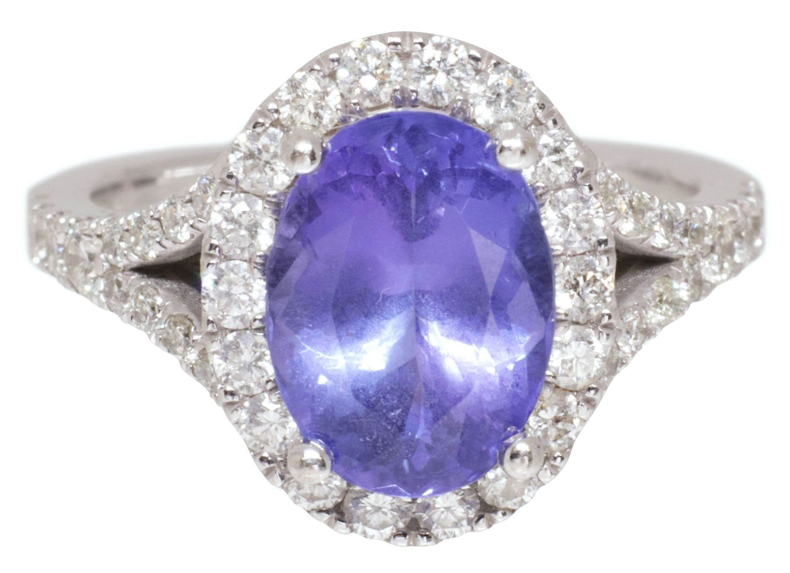 ESTATE 14KT WHITE GOLD, 2.88 CT TANZANITE & 1.50 CTTW DIAMOND HALO RING: Estate 14kt white gold and gemstone ring, a faceted blue oval tanzanite, approx 2.88cts, in a halo surround of round brilliant-cut diamonds, continuing to the shoulders, approx 1.50cttw, average color