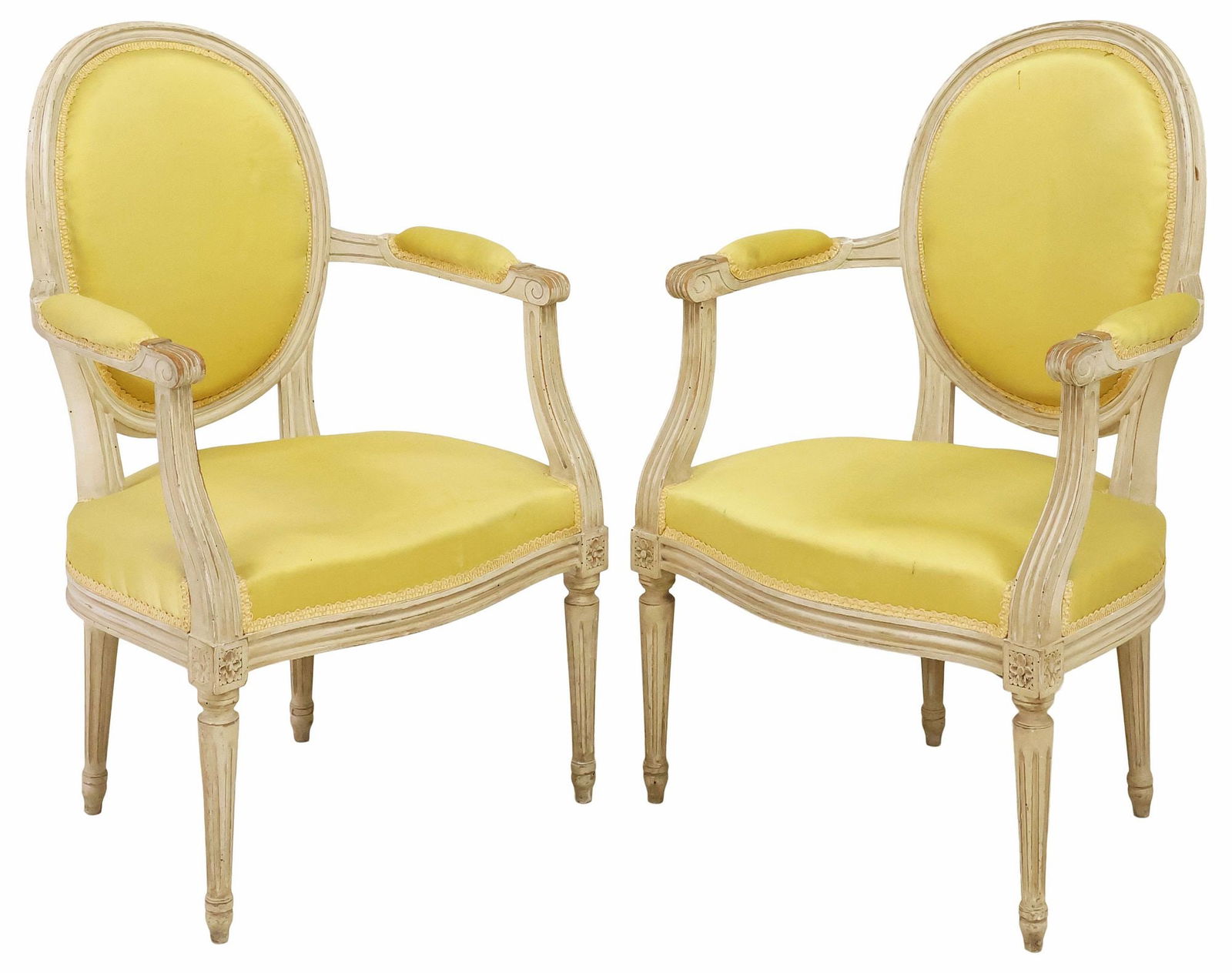 (2) FRENCH LOUIS XVI STYLE WHITE-PAINTED & UPHOLSTERED ARMCHAIRS: (pair) French Louis XVI style paint-decorated armchairs/ fauteuils, early 20th c., in an intentionally distressed white-painted finish, padded back, arms, and seat in a worn yellow satin upholstery, w