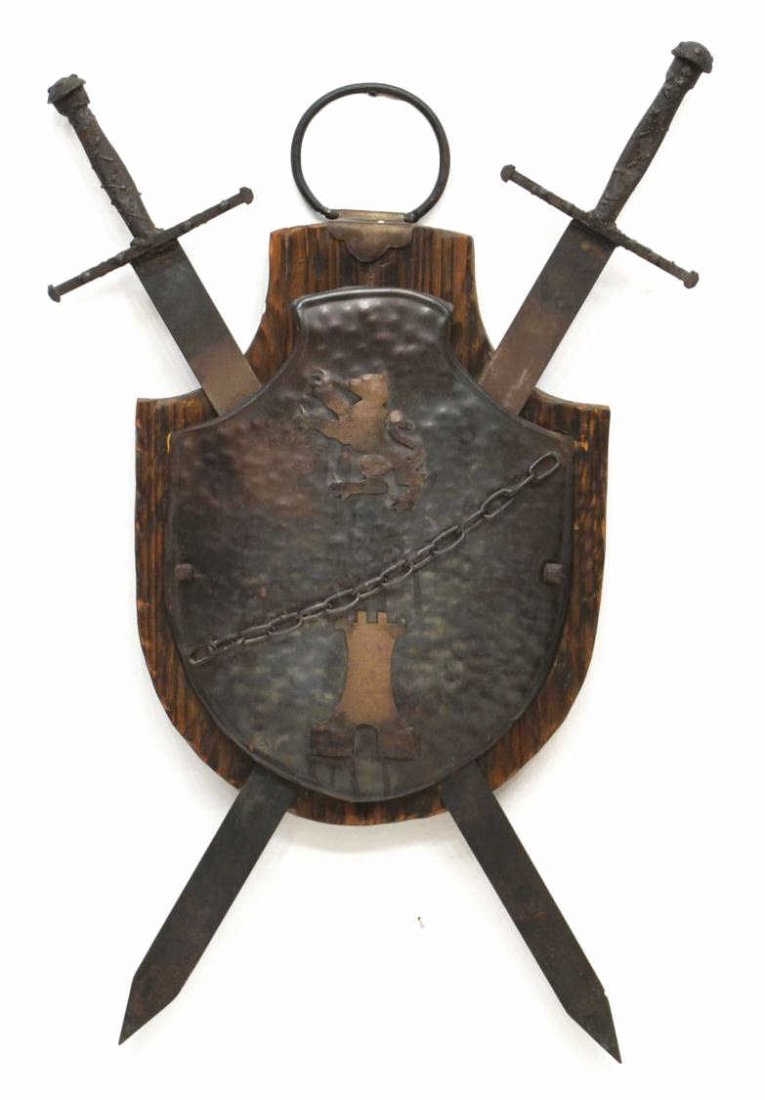 HERALDIC COAT OF ARMS, LION RAMPANT, CASTLE: A coat of arms, hammered metal fronting crossed swords, center depicting a lion rampant and castle with chain overlay, mounted on a conforming wood plaque, some wear to sword handles, approx 42"h, 27.