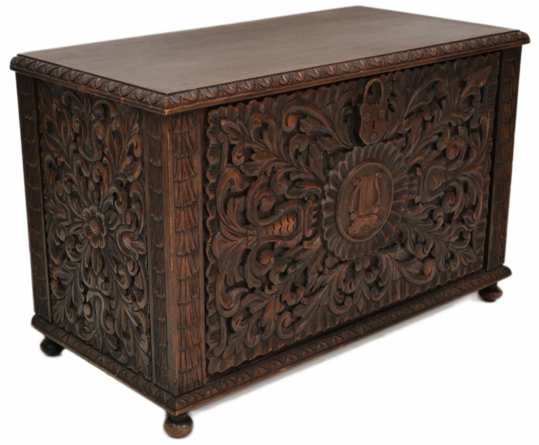 HEAVILY CARVED FALL FRONT CHEST, SPAIN: Heavily carved walnut vargueno, Spain, the rectangular case carved on three sides in relief with profuse foliates, fall front with carved lock form escutcheon, opening to sectioned interior, on small 