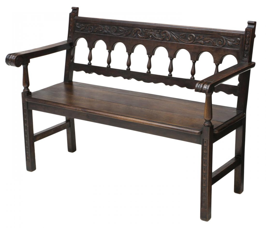 CONTINENTAL CARVED GARDEN BENCH: Continental carved garden bench having an arcaded backrest below rail of foliate carving, one hand hold lacking wood underneath, plank seat raised on a simple base, weathered, 36”h, 49.25”w, 20.5�