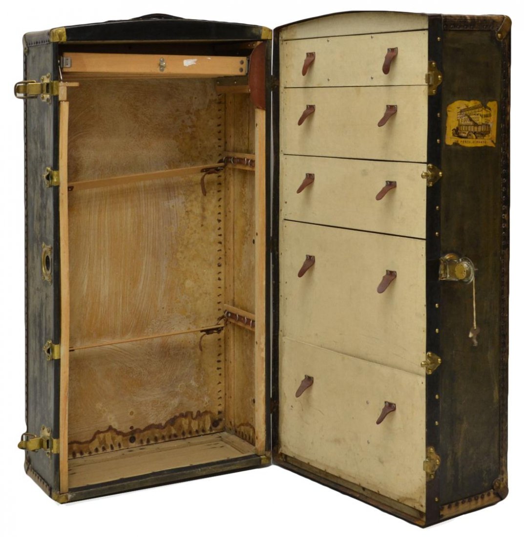 ANTIQUE METAL & LEATHER BOUND STEAMER TRUNK: An antique steamer trunk, metal and leather binding on the whole accented with small tacks, remnants of travel stickers including ‘The Grand Hotel Paris’, the interior well fitted with five gradua