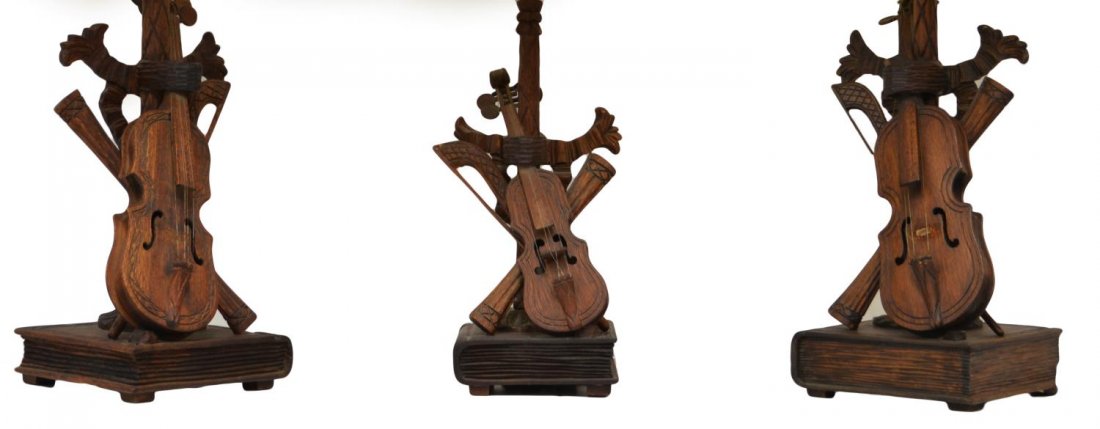 (3) BRAZILIAN CARVED TABLE LAMPS, VIOLIN & BOOK: (lot of 3) Brazilian carved wood table lamps, including (pair) large lamps having black shades, each with some loss, (1) smaller with off white shade, the carved form of a violin and rolled music rest