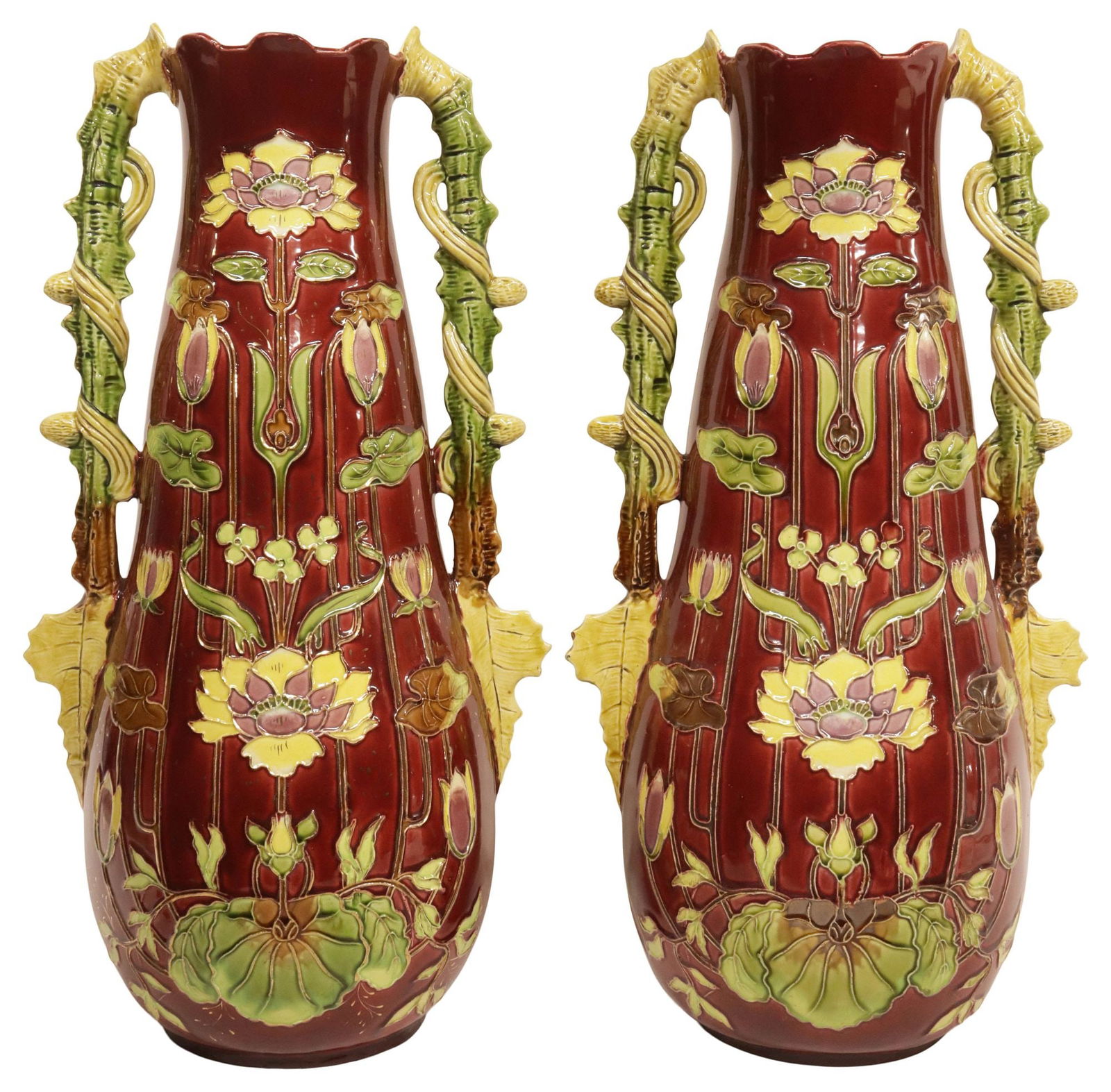 (2) LARGE FRENCH ART NOUVEAU MAJOLICA FOLIATE VASES, 19.5"H: (pair) French Art Nouveau Barbotine majolica vases, early 20th c., flared petal top over dual foliate handles, framing elongated body with incised floral motifs, and parcel-gilt accents, illegible