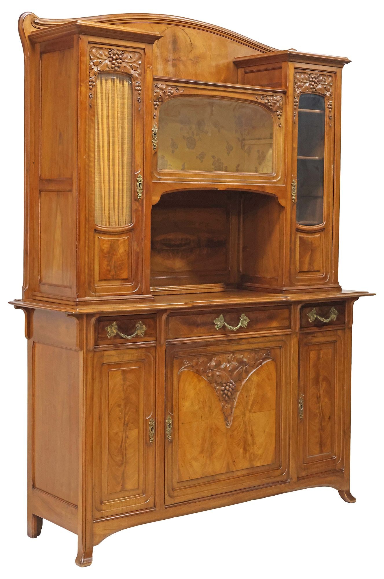 FRENCH ART NOUVEAU PERIOD CARVED WALNUT SIDEBOARD WITH GRAPES: French Art Nouveau walnut buffet deux corps, retailed by Louis Chambry, Paris, early 20th c., having arched back, above central glazed cabinet, fabric-lined open storage interior, flanked by
