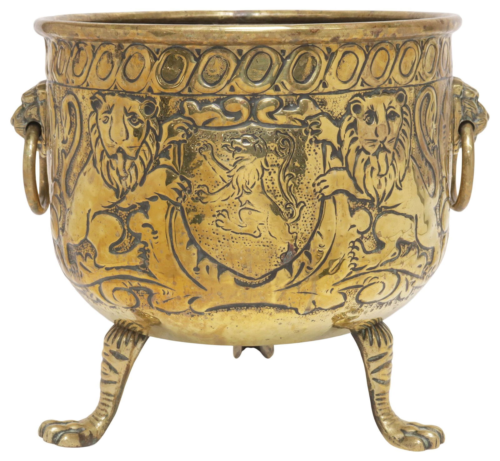ENGLISH REGENCY PERIOD BRASS ARMORIAL MOTIF JARDINIERE/ PLANTER: English Regency period brass jardiniere, early 19th c., having dual lion mask ring handles, above repousse running ornamentation with central armorial crest, flanked by rampant lions, ending on tripod