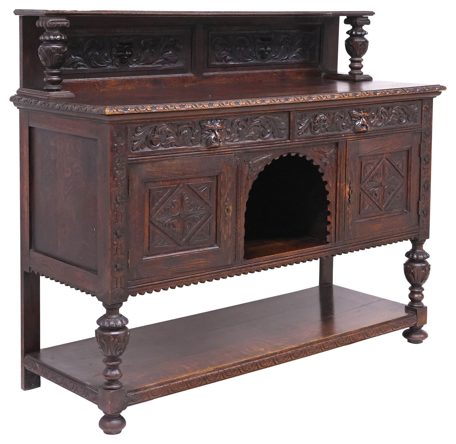 ENGLISH VICTORIAN CARVED OAK 'GREEN MAN' SIDEBOARD: English Victorian carved oak sideboard, 19th c., having raised and paneled back, rectangular case with foliated trim, fitted with two drawers, "Green Man" motif pulls, above arched open compartment,