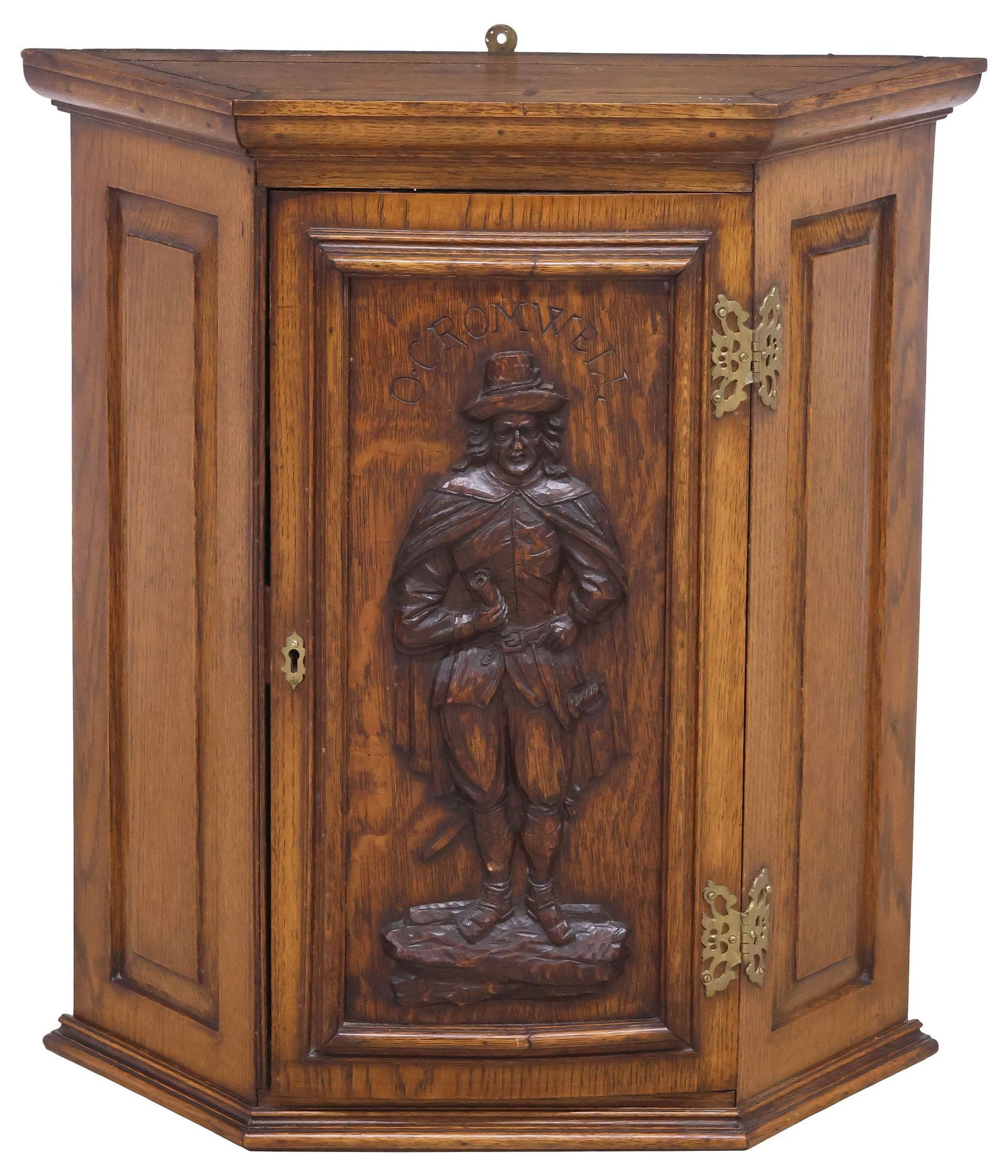 ENGLISH CARVED OAK WALL-MOUNTED CABINET WITH OLIVER CROMWELL: English carved oak wall-hanging cabinet, early 20th c., of trapezoidal shape, with molded cornice, over single paneled door with carved full-length portrait of Oliver Cromwell, enclosing fixed-height
