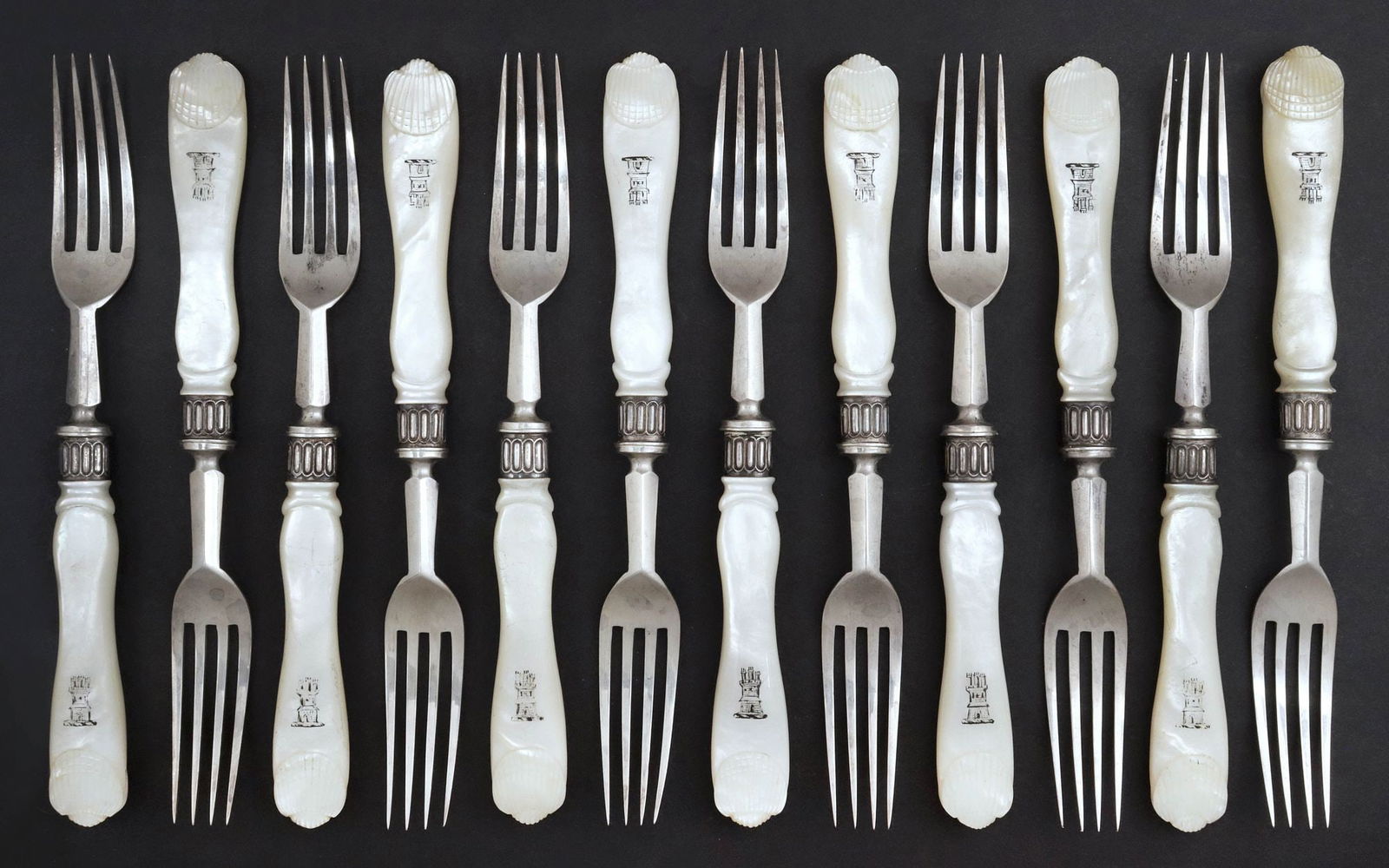 (12) MAPPIN & WEBB VICTORIAN STERLING & MOTHER-OF-PEARL FRUIT FORKS: (lot of 12) English Victorian fruit/ service forks, Mappin & Webb, c.1899-1900, sterling times, mother-of-pearl handles engraved with heraldic castle turret, terminating in a carved shell motif, Sheff