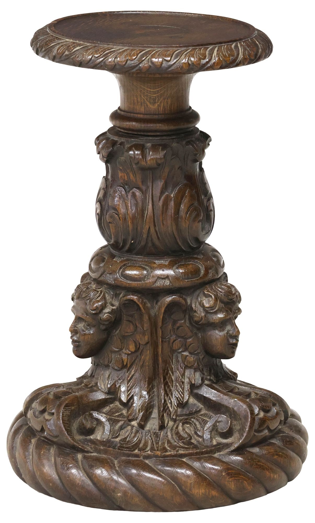 RENAISSANCE REVIVAL CARVED OAK FIGURAL PEDESTAL / PLANT STAND: Renaissance Revival carved oak plant stand/ pedestal, late 19th c., having round top with foliate trim, figural standard with winged cherub masks, terminating on gadrooned circular base, approx 19"h,