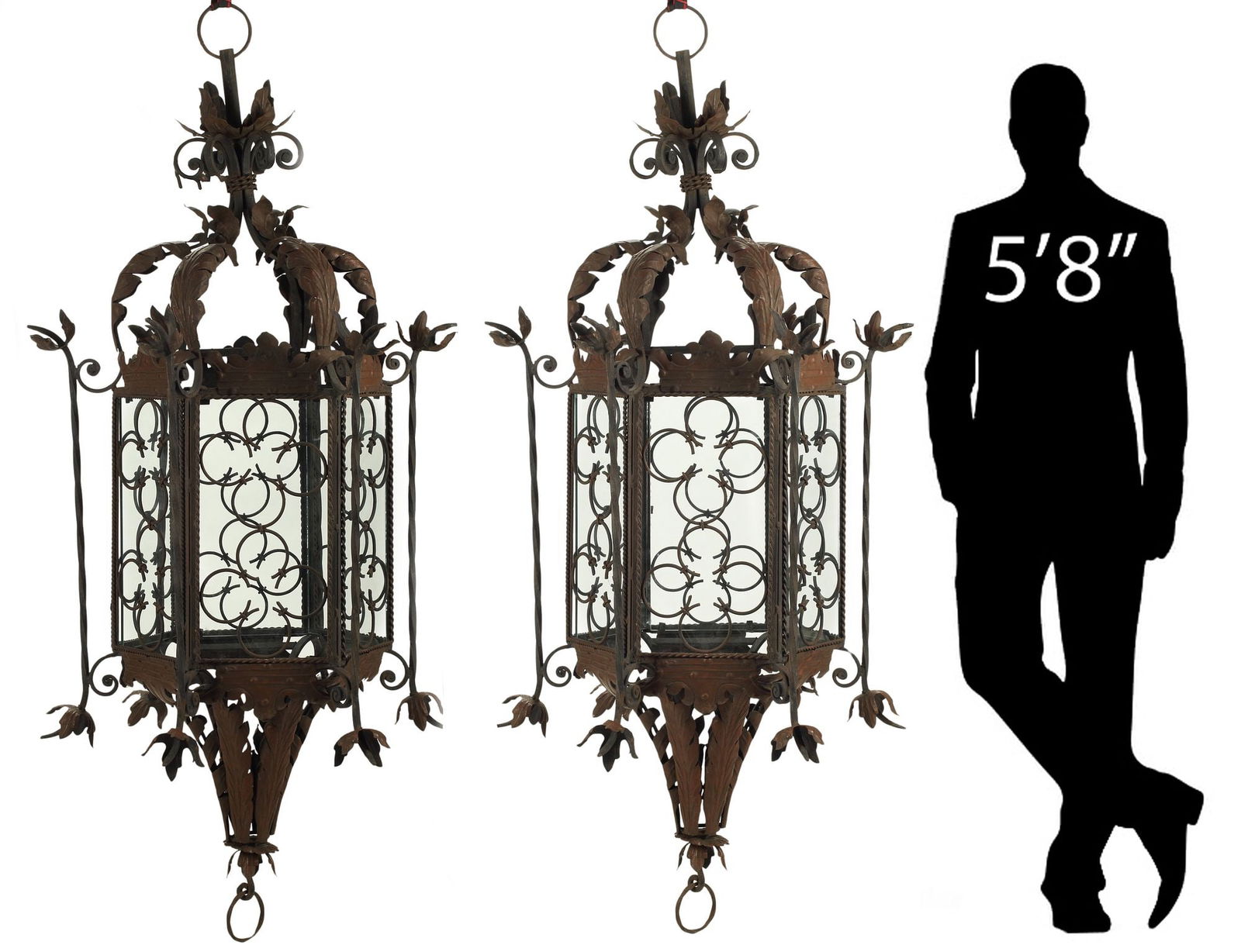 (2) MONUMENTAL FOLIATED WROUGHT IRON & TOLE HANGING LANTERNS, 69"H: (pair) Monumental Spanish-style wrought iron and tole hanging lanterns, of hexagonal form, with applied foliates and quatrefoil patterns, fitted with glass panes, in need of sockets and wiring,