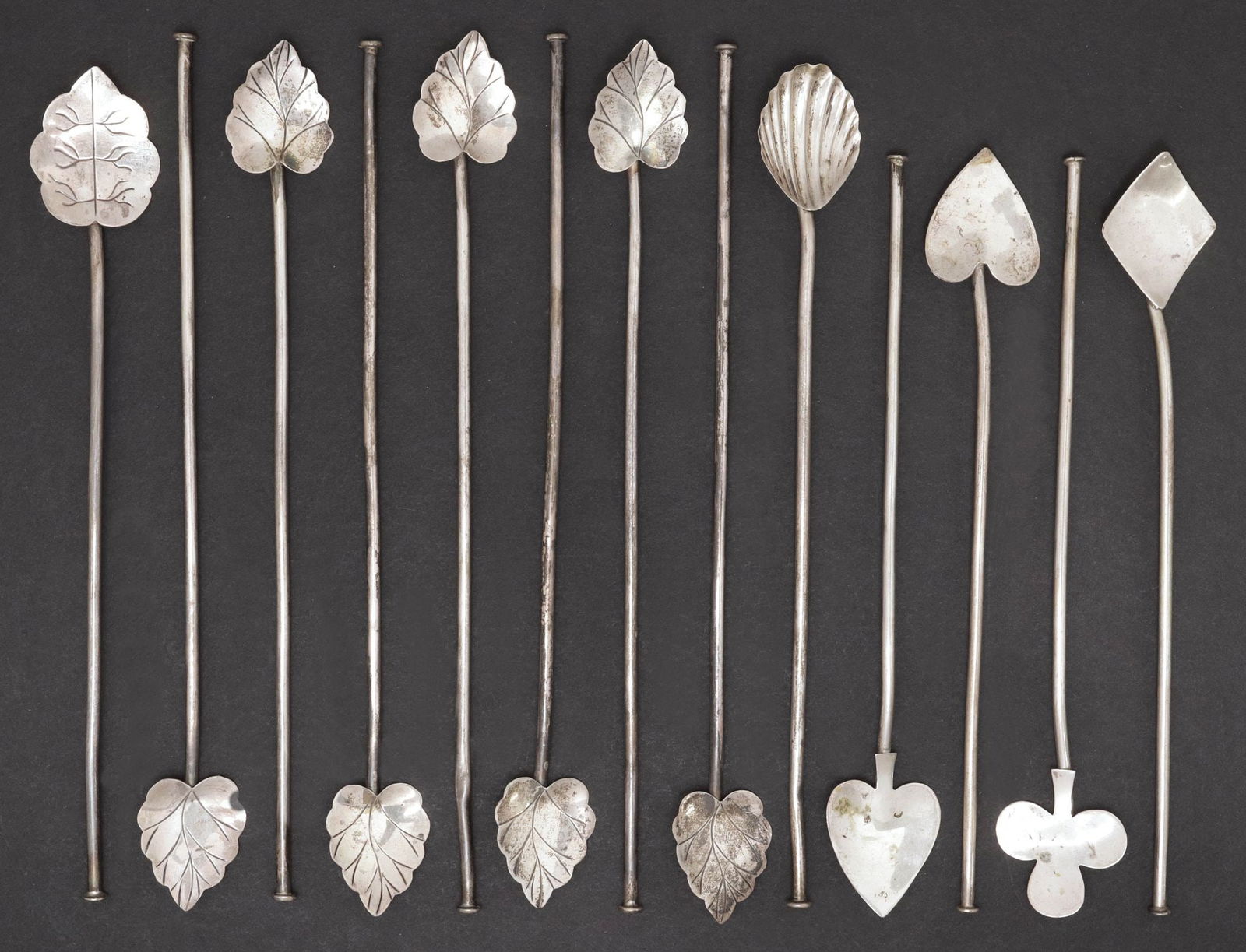 (13) MEXICO STERLING SILVER COCKTAIL STIRS, PLAYING CARD SUITS & LEAVES: (lot of 13) Sterling silver stir sticks \ straws, Mexico, each having figural topper, marked underfoot, including: (8) veined leaves, (4) playing card suits, (one) heart, (one) club, (one) diamond, (o