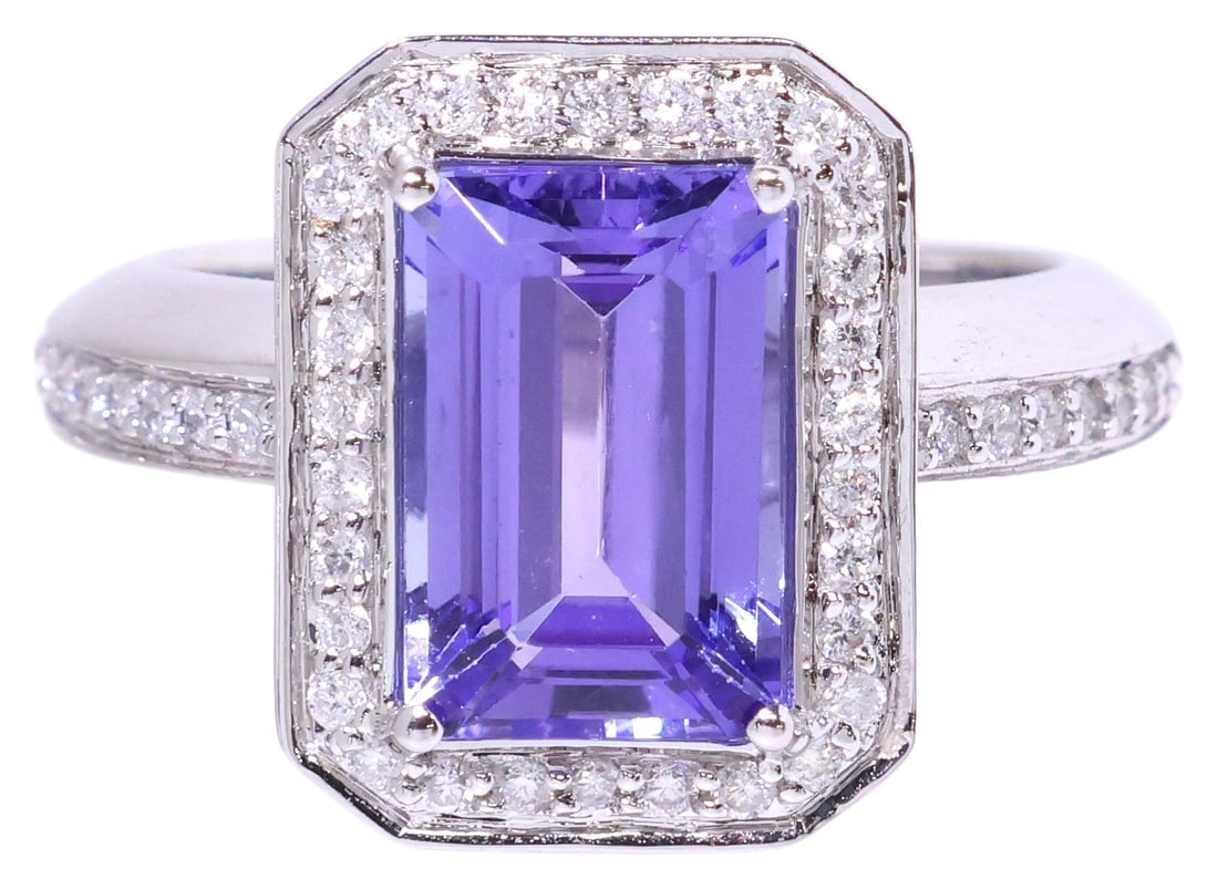 ESTATE 14KT WHITE GOLD, 3.50CT TANZANITE & DIAMOND HALO RING: Estate 14kt white gold (tested) and gemstone ring, a central emerald-cut tanzanite, approx 3.50cts, in a halo surround of round-cut diamonds, continuing to the shoulders, approx 0.50cttw, average