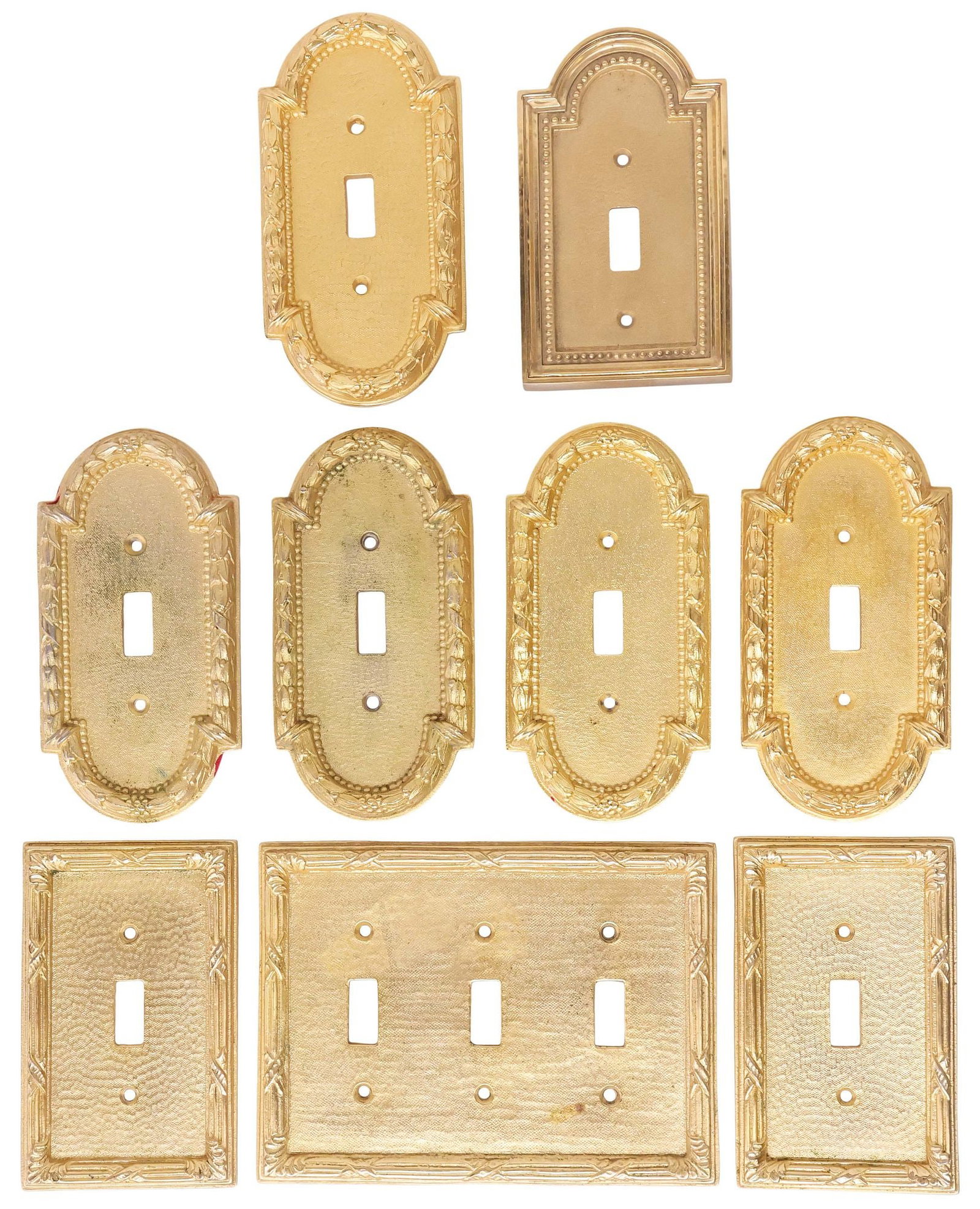 (9) DESIGNER SHERLE WAGNER GILT BRASS LIGHT SWITCH PLATES: (lot of 9) Designer modern gilt brass light switch plates, Sherle Wagner International, 20th c., including: (5) in the "Acanthus" pattern, (3) in the "Ribbon and Reed" pattern, (one) in a three-switch