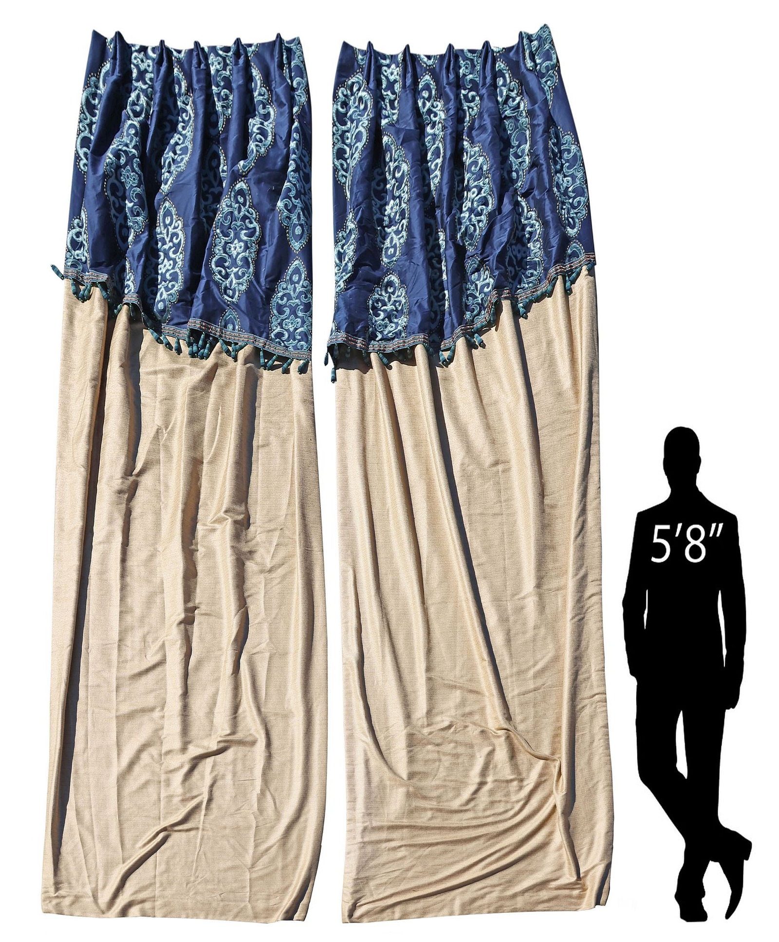 (2) CUSTOM-MADE CURTAINS WITH TASSELED VALANCES, 130"L X 24"W: (pair) Custom-made curtains, each in a pale gold fabric, with attached slanted blue valance, and tasseled trim, having sewn-in pleats and silver-toned hooks at top, lined with two panels of white fabr