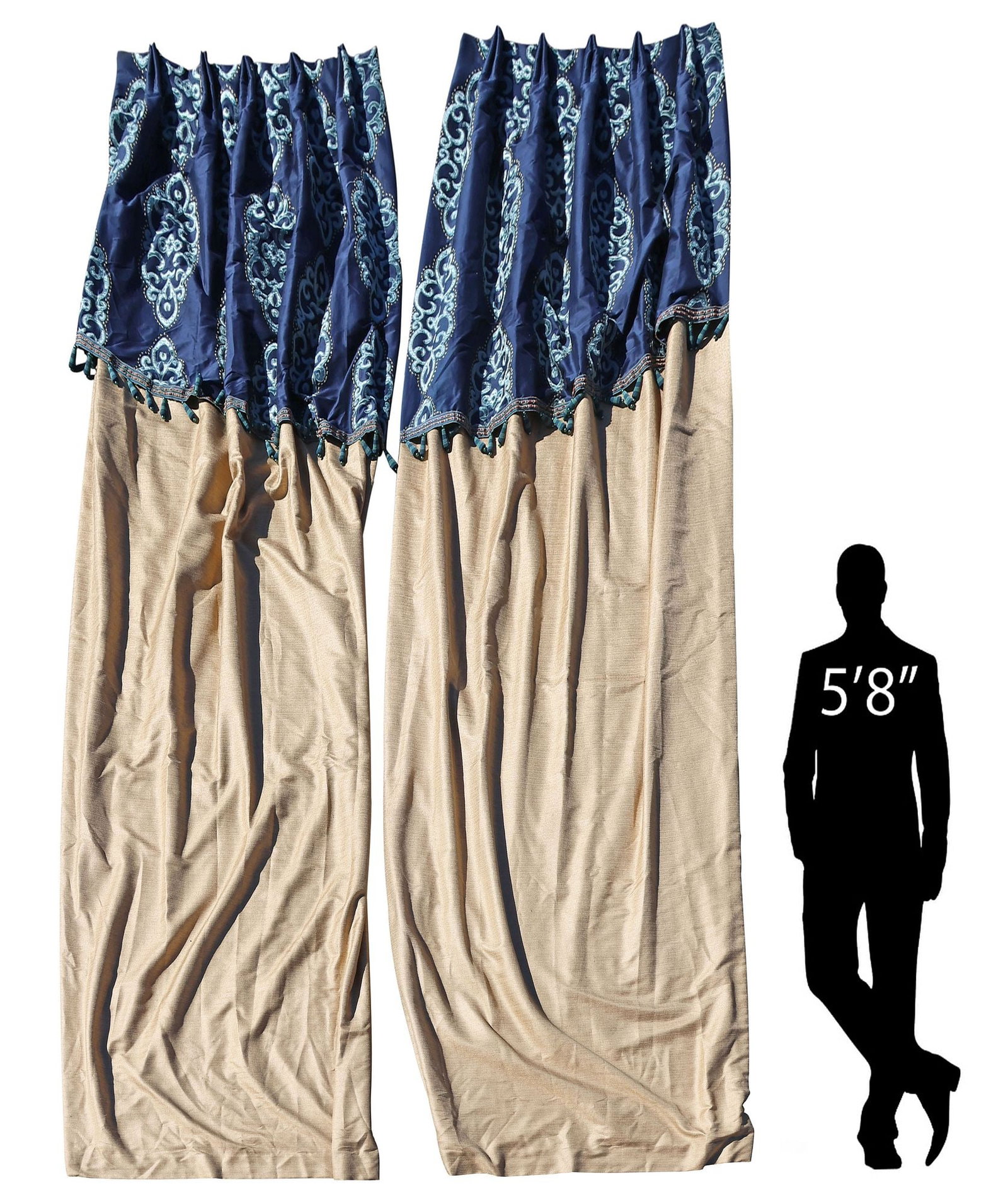 (2) CUSTOM-MADE CURTAINS WITH TASSELED VALANCES, 130"L X 24"W: (pair) Custom-made curtains, in a pale gold fabric, with attached slanted blue valance, and tasseled trim, having sewn-in pleats and silver-toned hooks at top, lined with two panels of white fabric, b