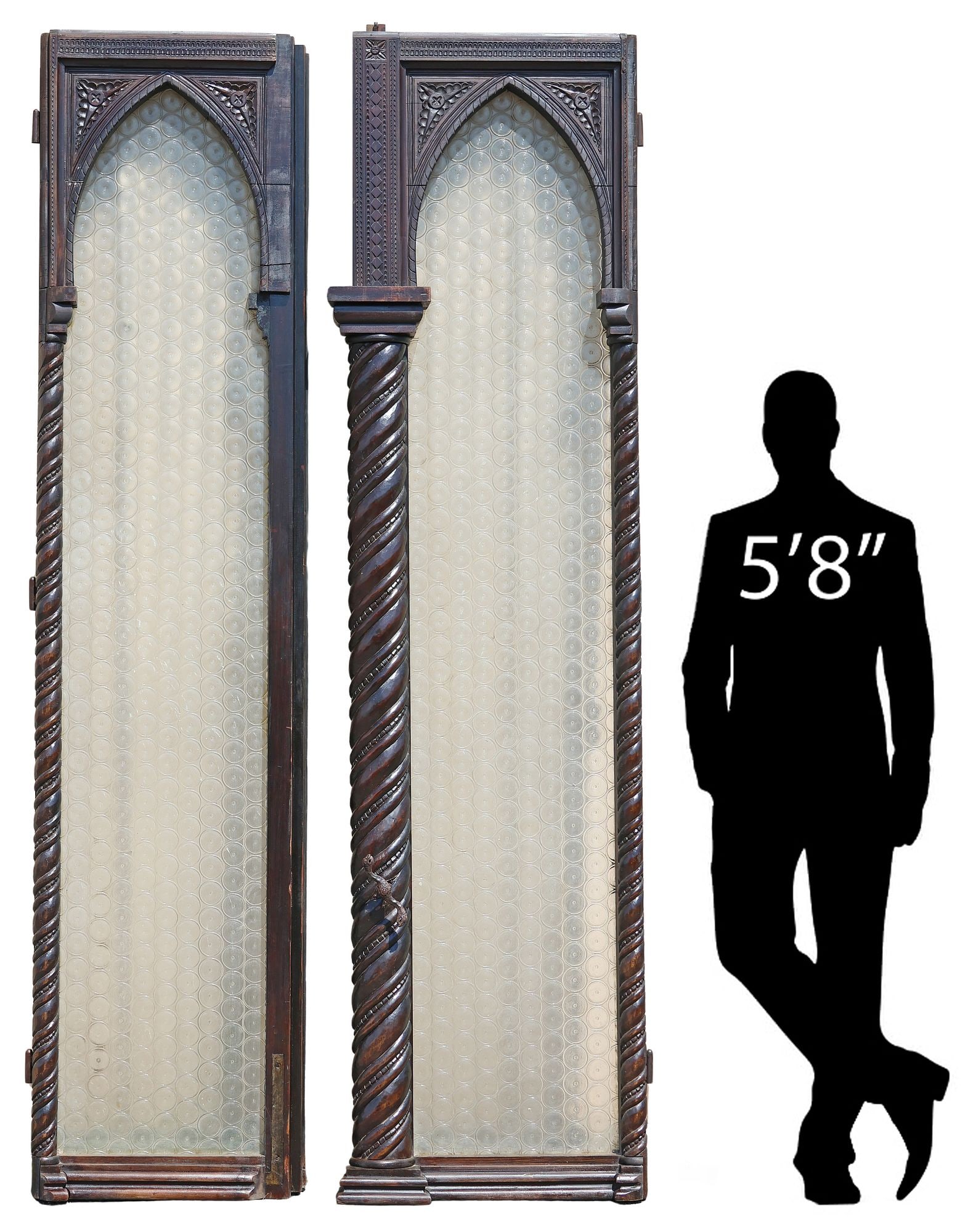 (2) LARGE GOTHIC REVIVAL CARVED WALNUT & GLASS ARCHITECTURAL DOORS: (lot of 2) Large Continental Gothic Revival carved architectural doors, 19th c., steepled frames with twisted and beaded trim, encasing panes of colorless textured bullseye glass, (one) equipped with
